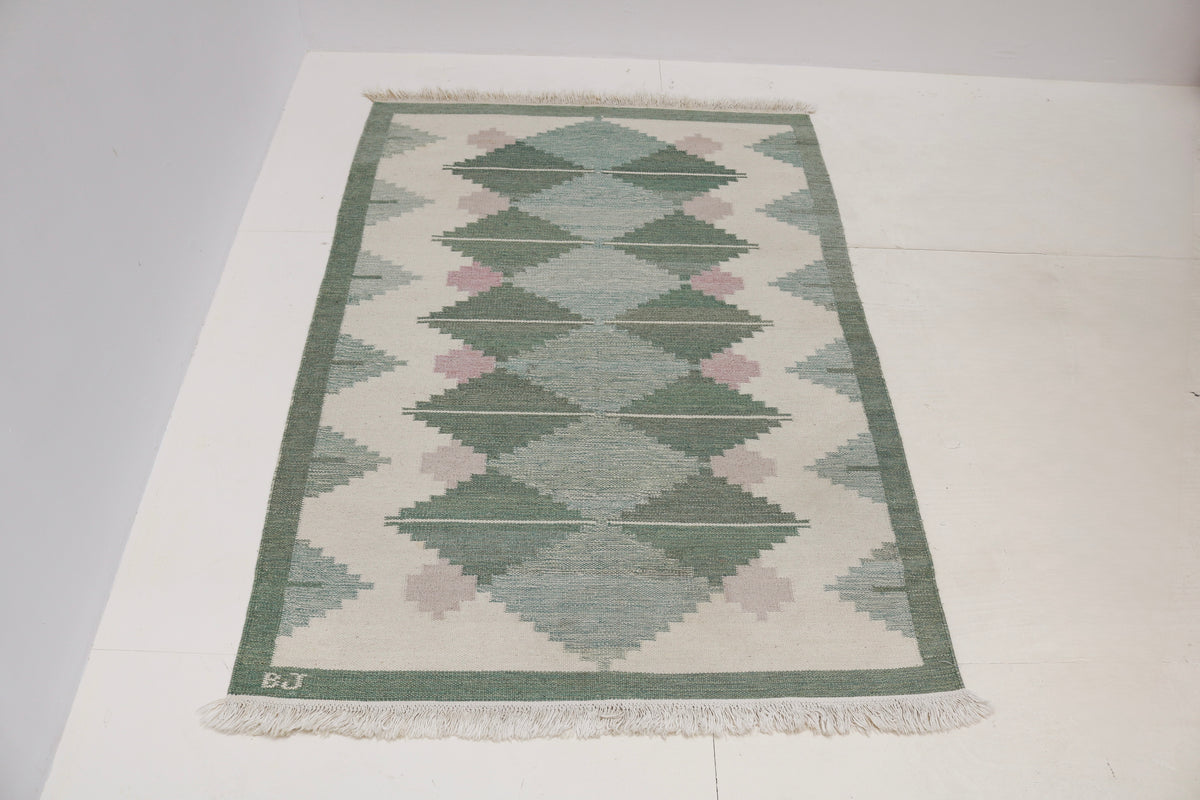 Full view of vintage Swedish Kilim rug with repeating central diamond pattern