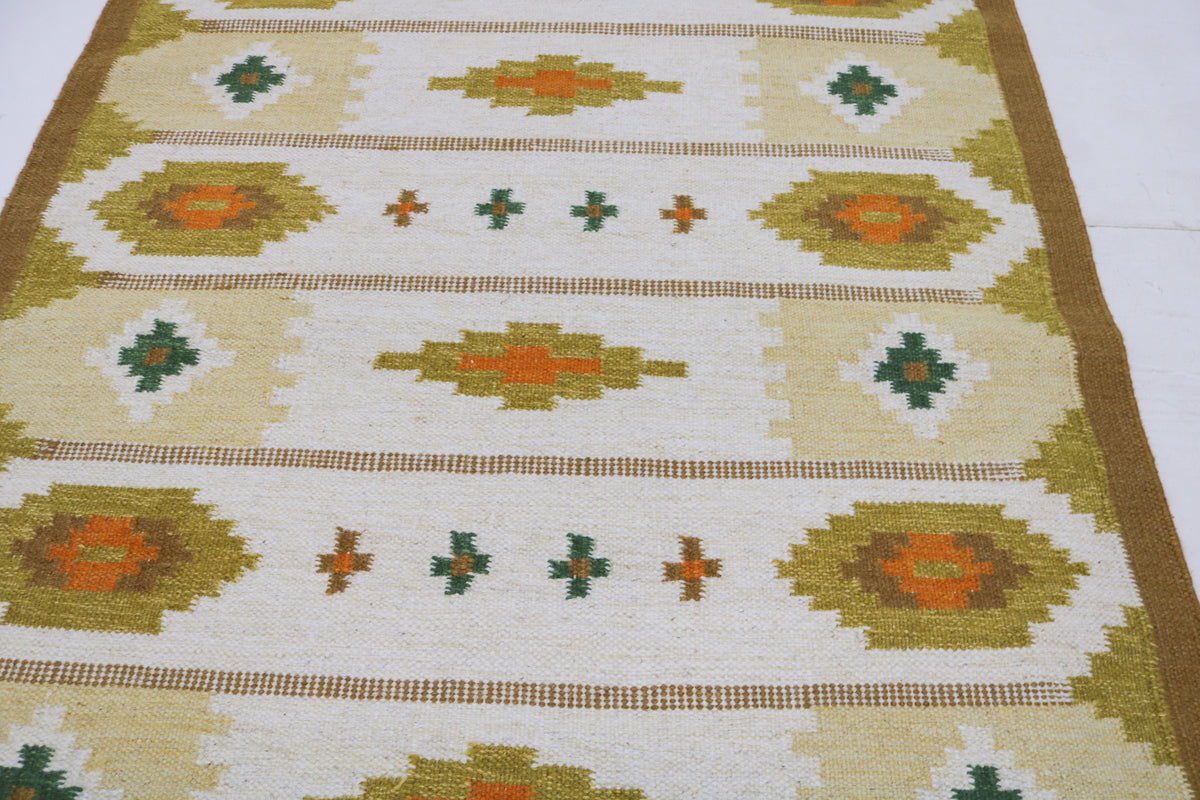 Detailed Swedish Kilim rug surface featuring warm geometric medallions and small decorative motifs
