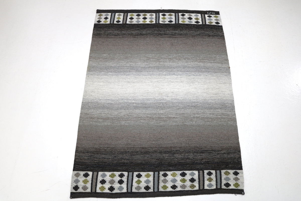 Full Swedish Kilim showing tonal grey field with decorative floral end borders
