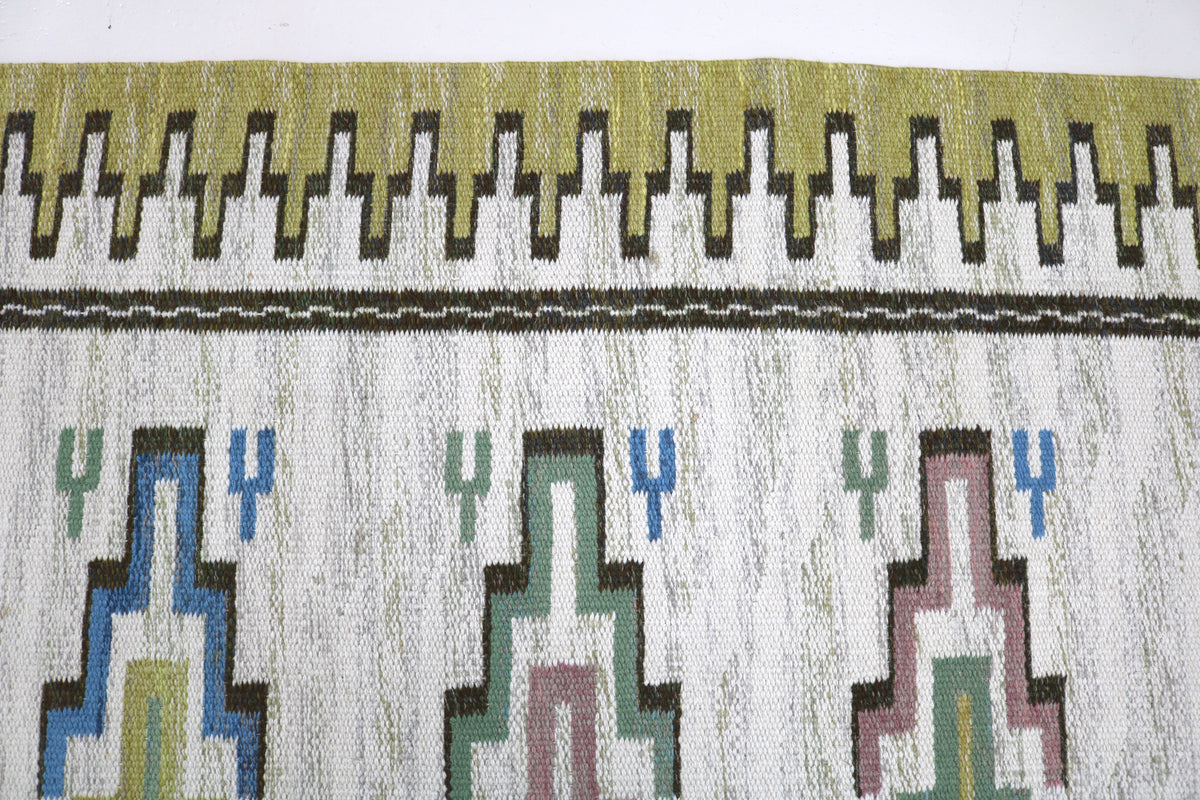Detailed vintage Swedish Kilim rug with colourful geometric patterns and olive border