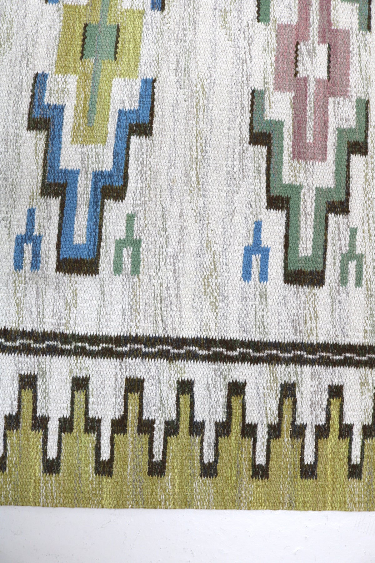 Close-up of Swedish Kilim rug showing geometric motifs and contrasting decorative border