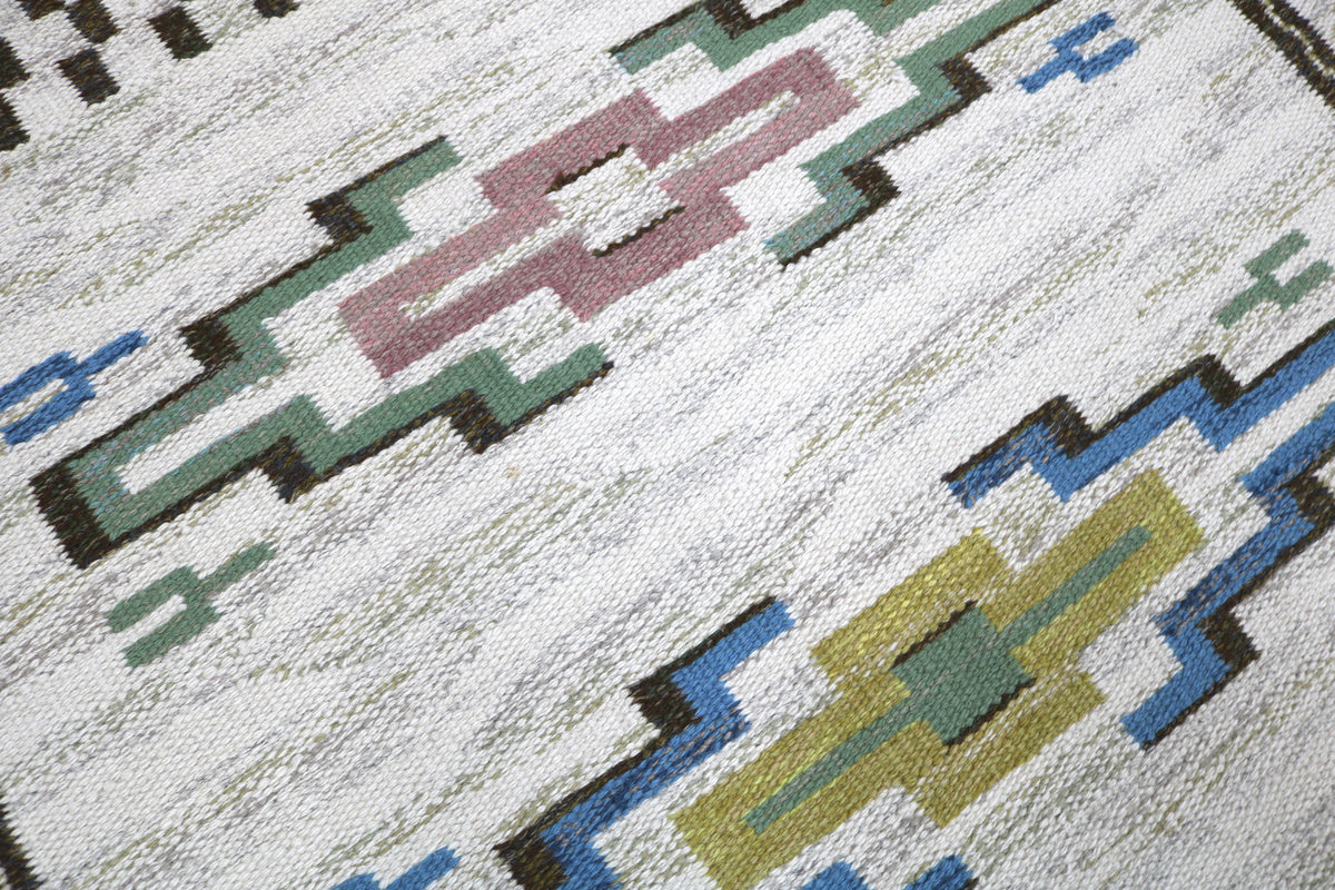 Close-up of vintage Kilim rug showing colourful geometric motifs and woven wool texture