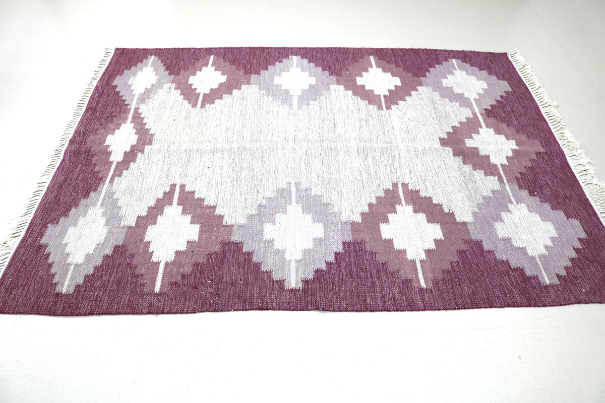 Vintage Swedish Kilim rug showing bold geometric pattern and contrasting burgundy border
