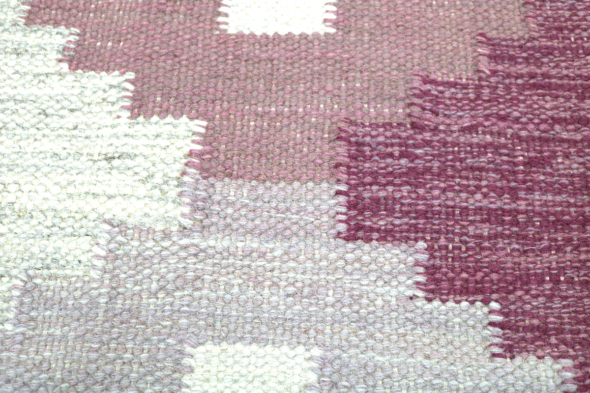 Detailed Swedish Kilim rug with burgundy geometric shapes and softly contrasting grey tones
