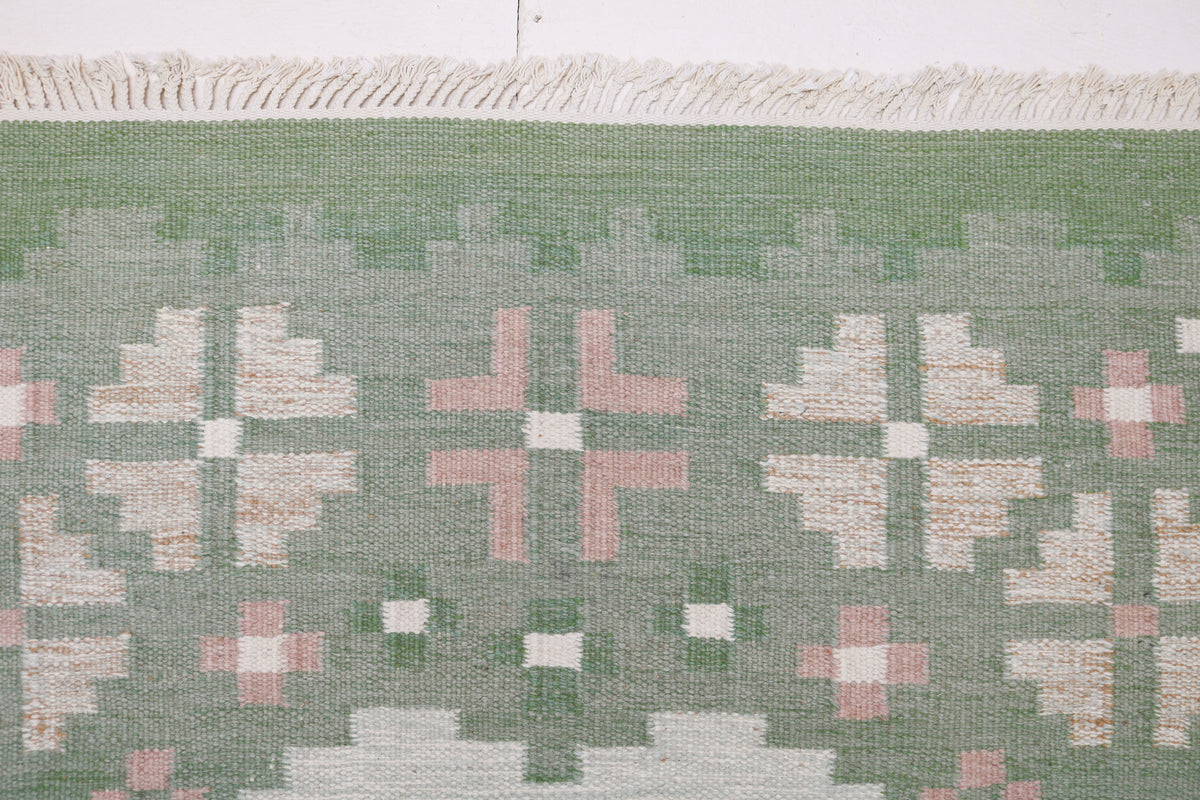 Detailed Swedish Kilim rug showing stylised cross and floral motifs along the border