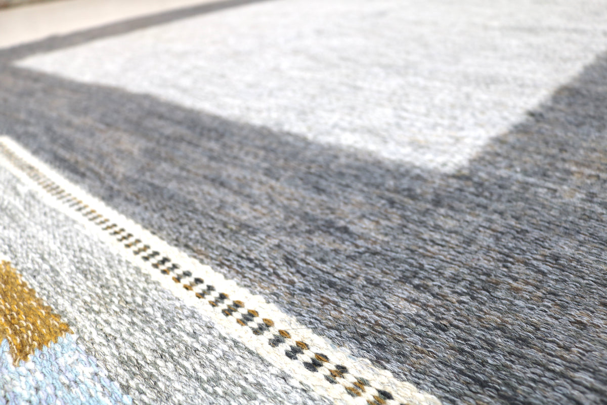Close-up of vintage Swedish Kilim rug showing grey field, fine border and woven texture
