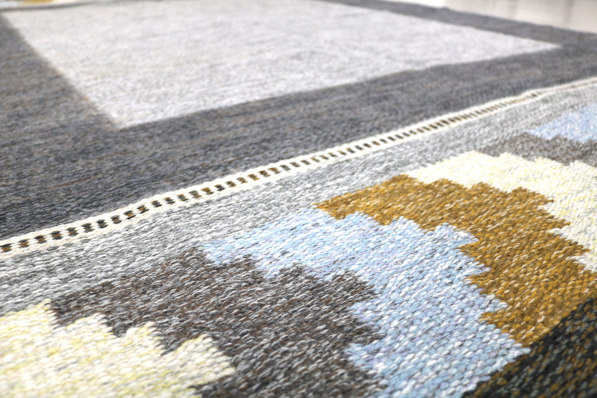 Detailed view of Swedish Kilim rug with geometric border and muted Scandinavian colour palette

