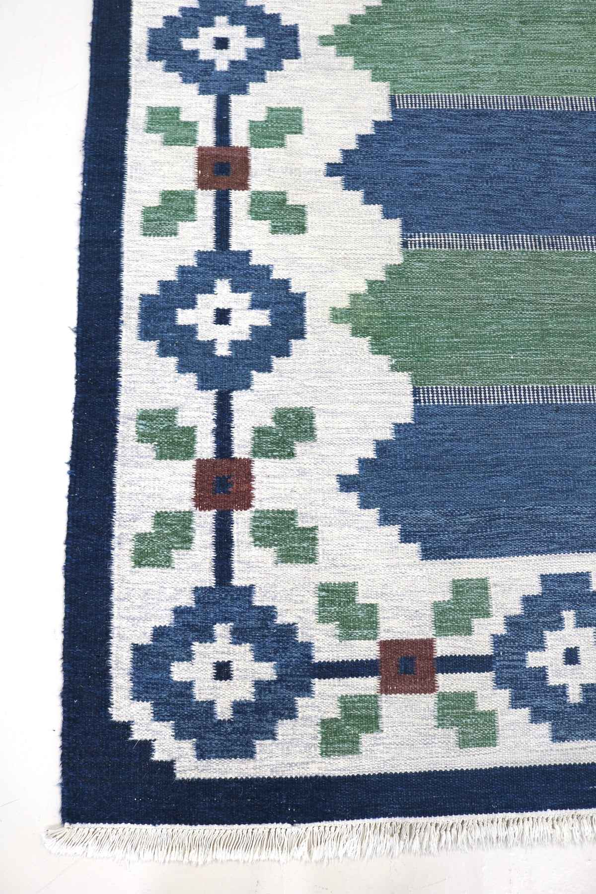 Vintage Swedish Kilim rug with ivory field, blue and green geometric motifs and dark border

