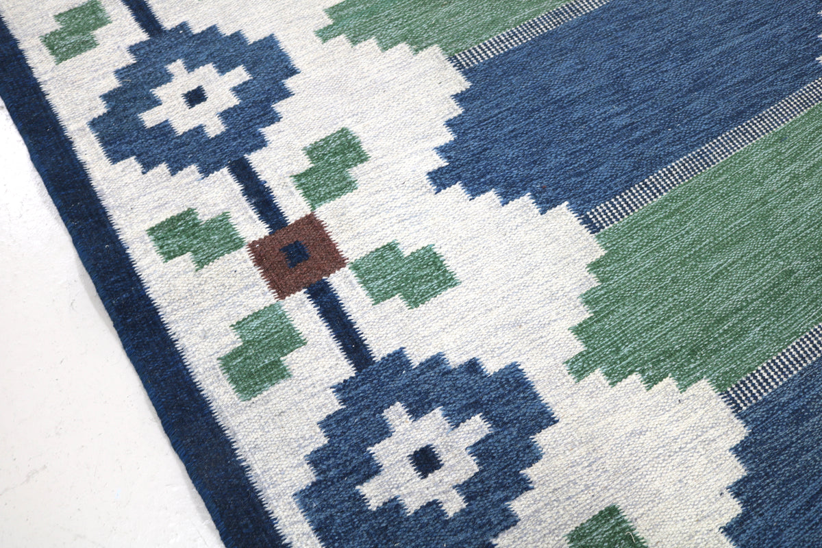 Detailed vintage Swedish Kilim rug corner showing geometric motifs, woven texture and muted colours