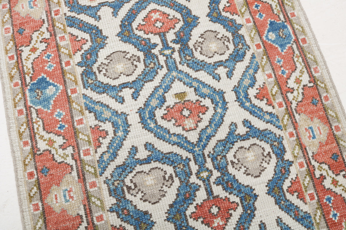 Close-up of Ushak runner pattern featuring blue geometric motifs with coral and grey accents