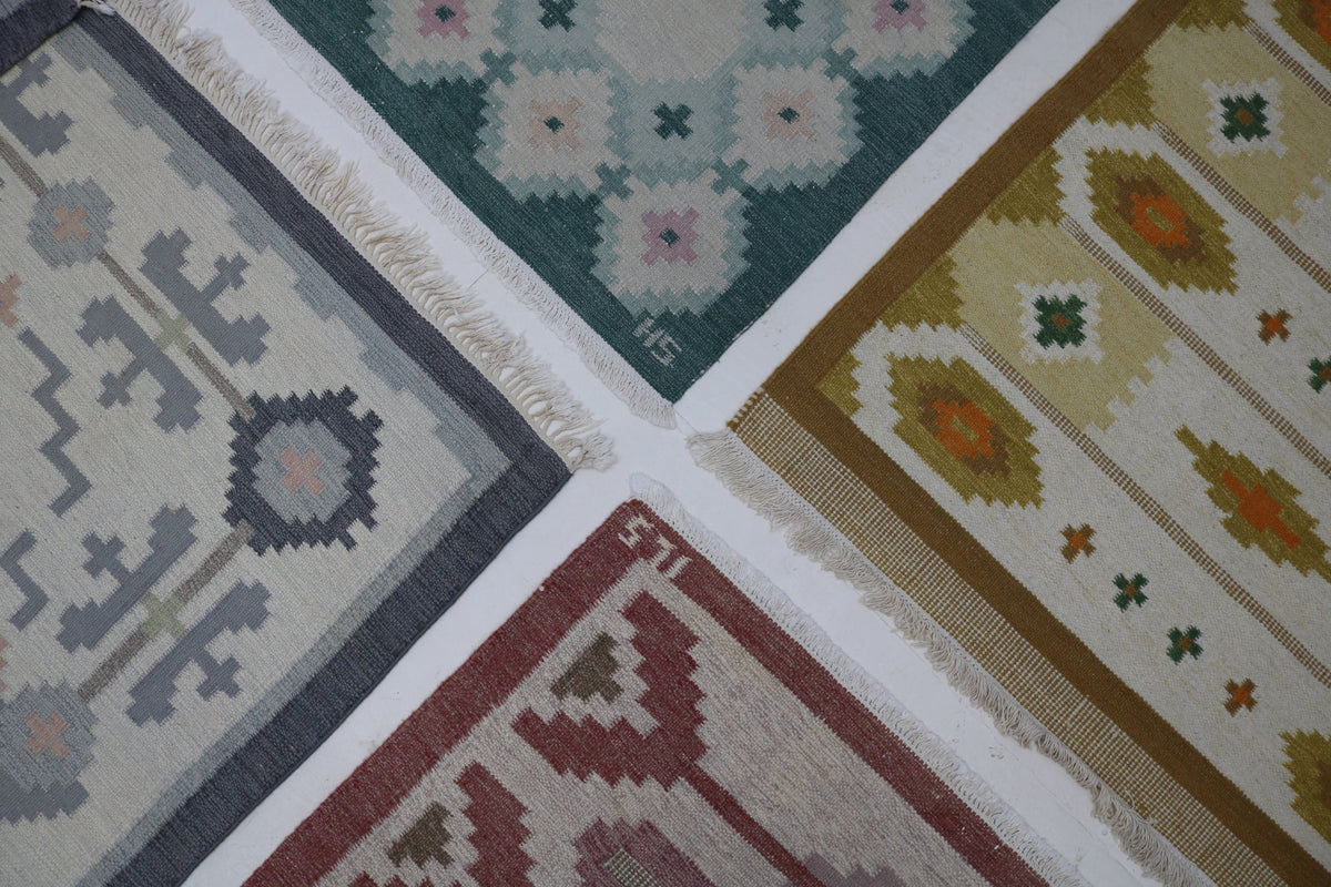 Four vintage Swedish rolakan kilims laid corner to corner, in grey, green, mustard and red