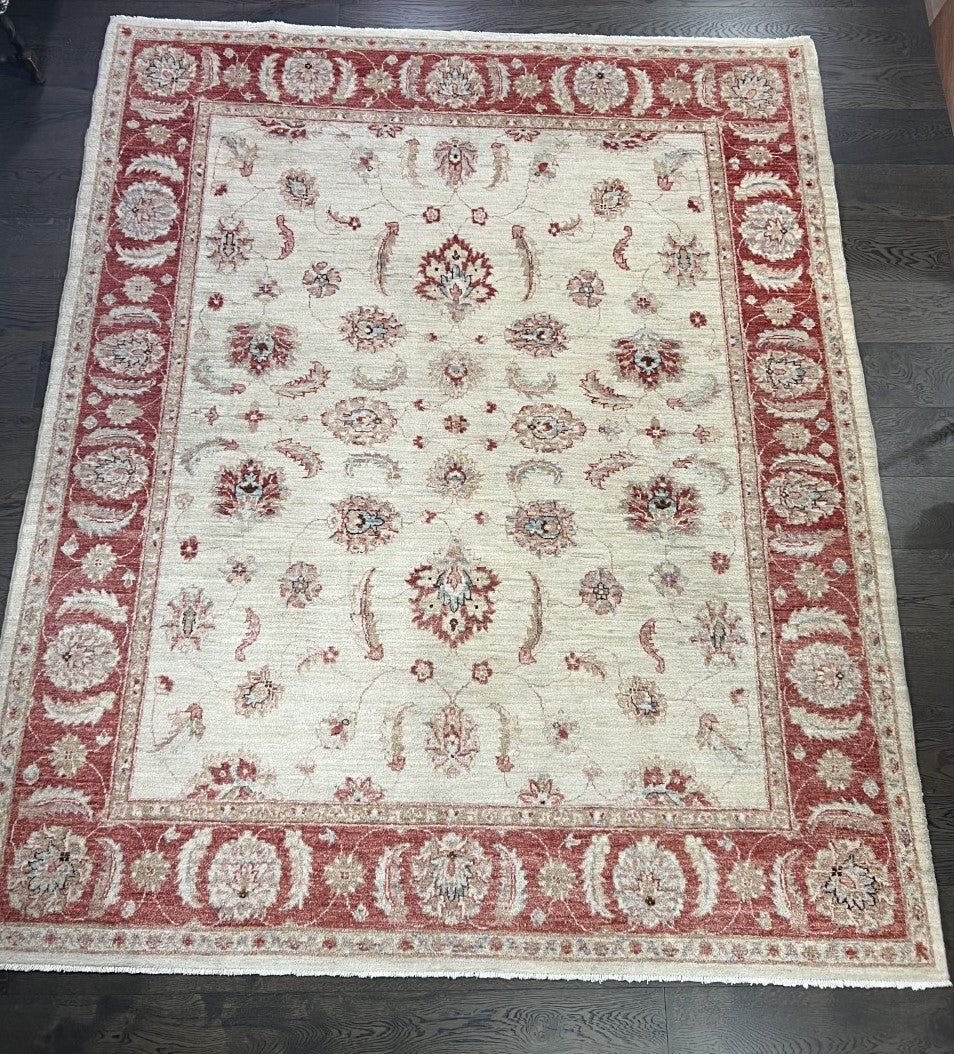 Full Afghan Ziegler rug showing ivory field framed by a rich red floral border