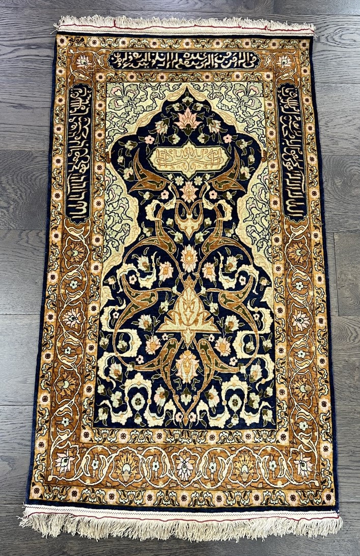 Full Hereke prayer rug showing symmetrical floral composition and richly decorated borders