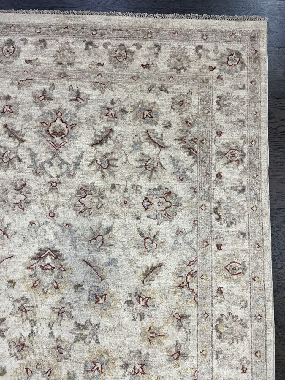 Detailed rug section with delicate floral patterns and softly contrasting decorative border