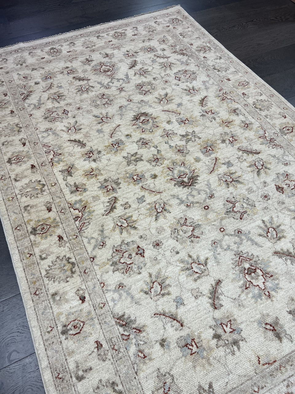 Angled view highlighting the soft ivory field and delicate floral detailing