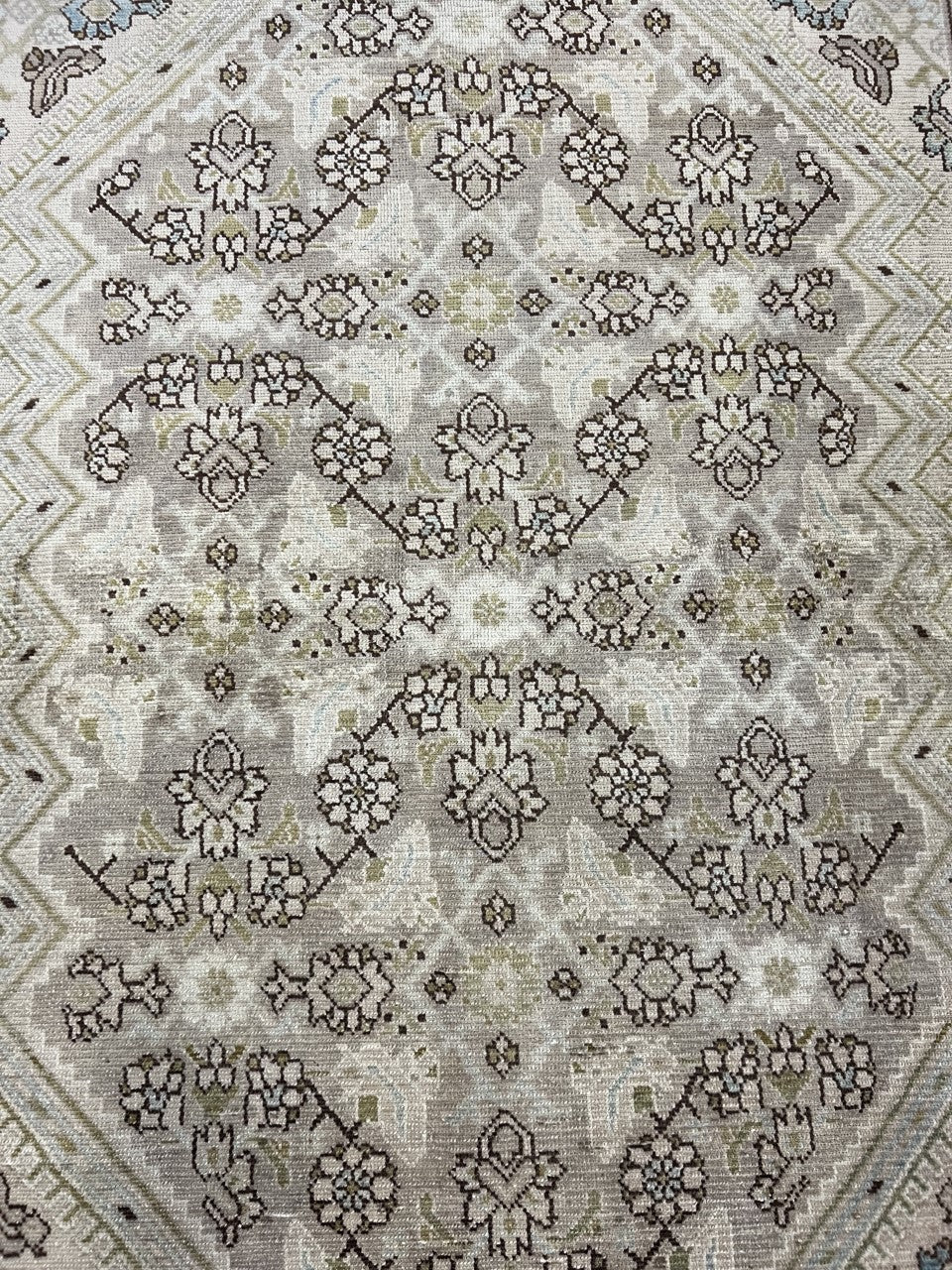 Close-up of Malayer rug with delicate repeating floral motifs across the field