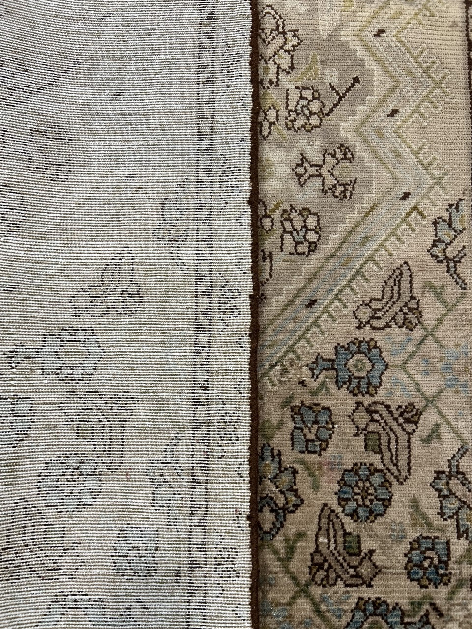 Side view of folded rug revealing detailed border and muted floral field