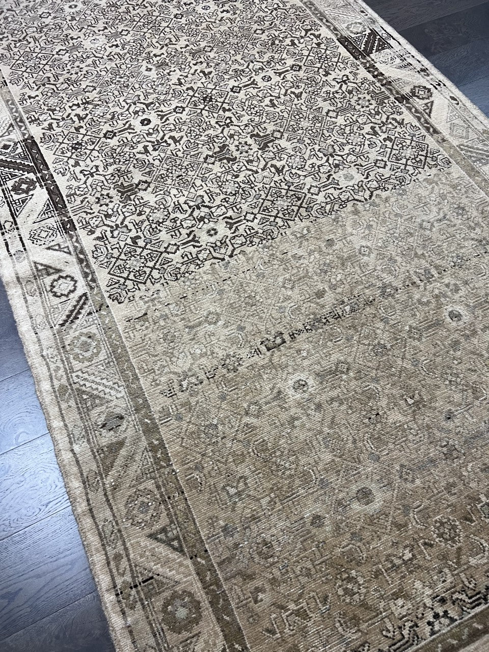 Angled view of Malayer rug showing subtle abrash and patterned border