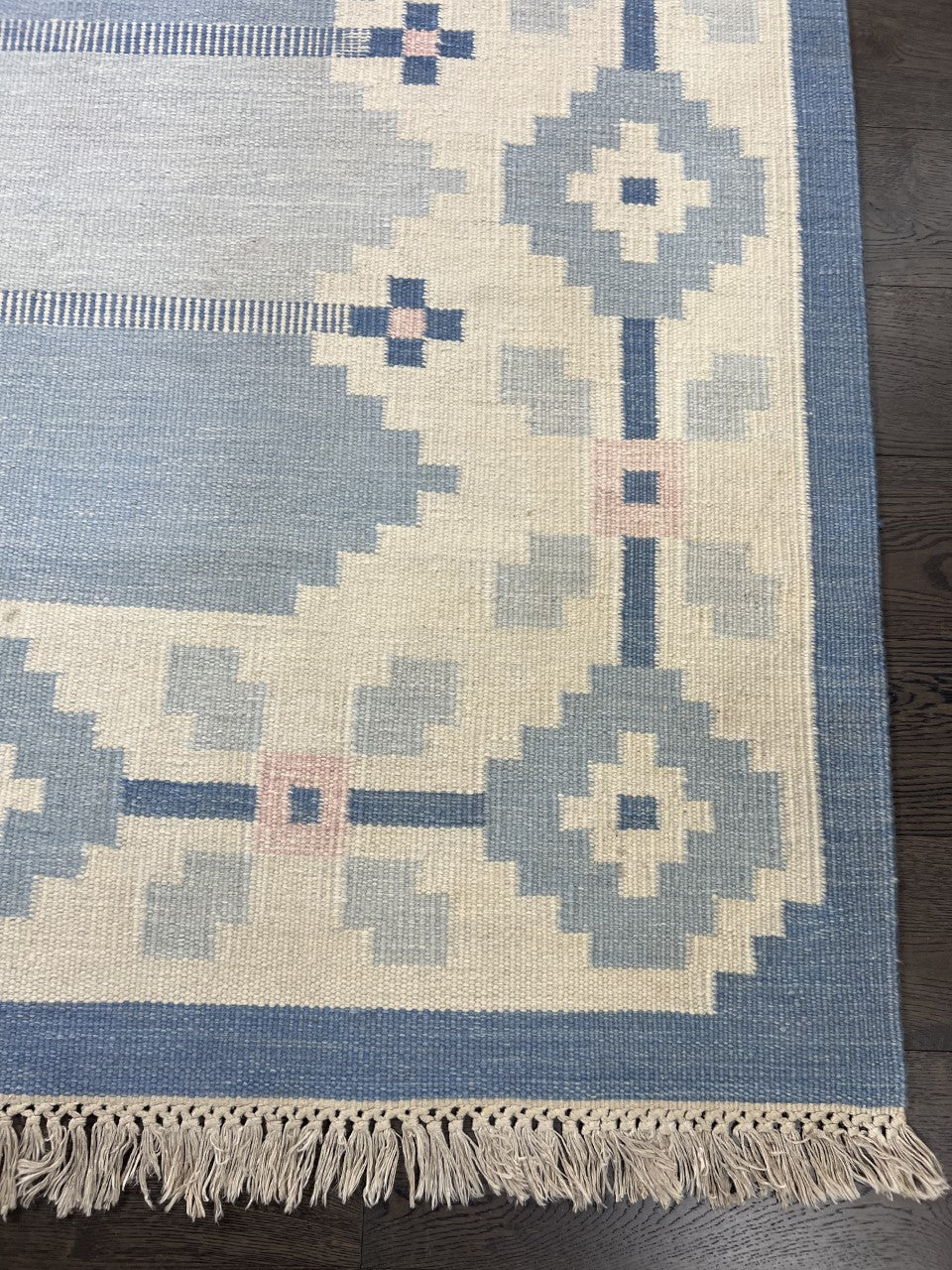 Swedish Kilim end showing geometric motifs with fringed edge and muted colours