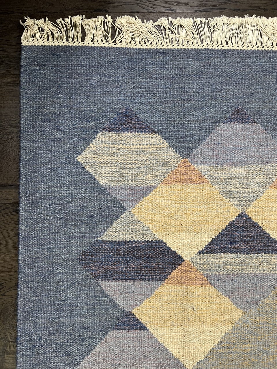 Detailed Kilim section showing geometric diamond shapes across a textured blue field