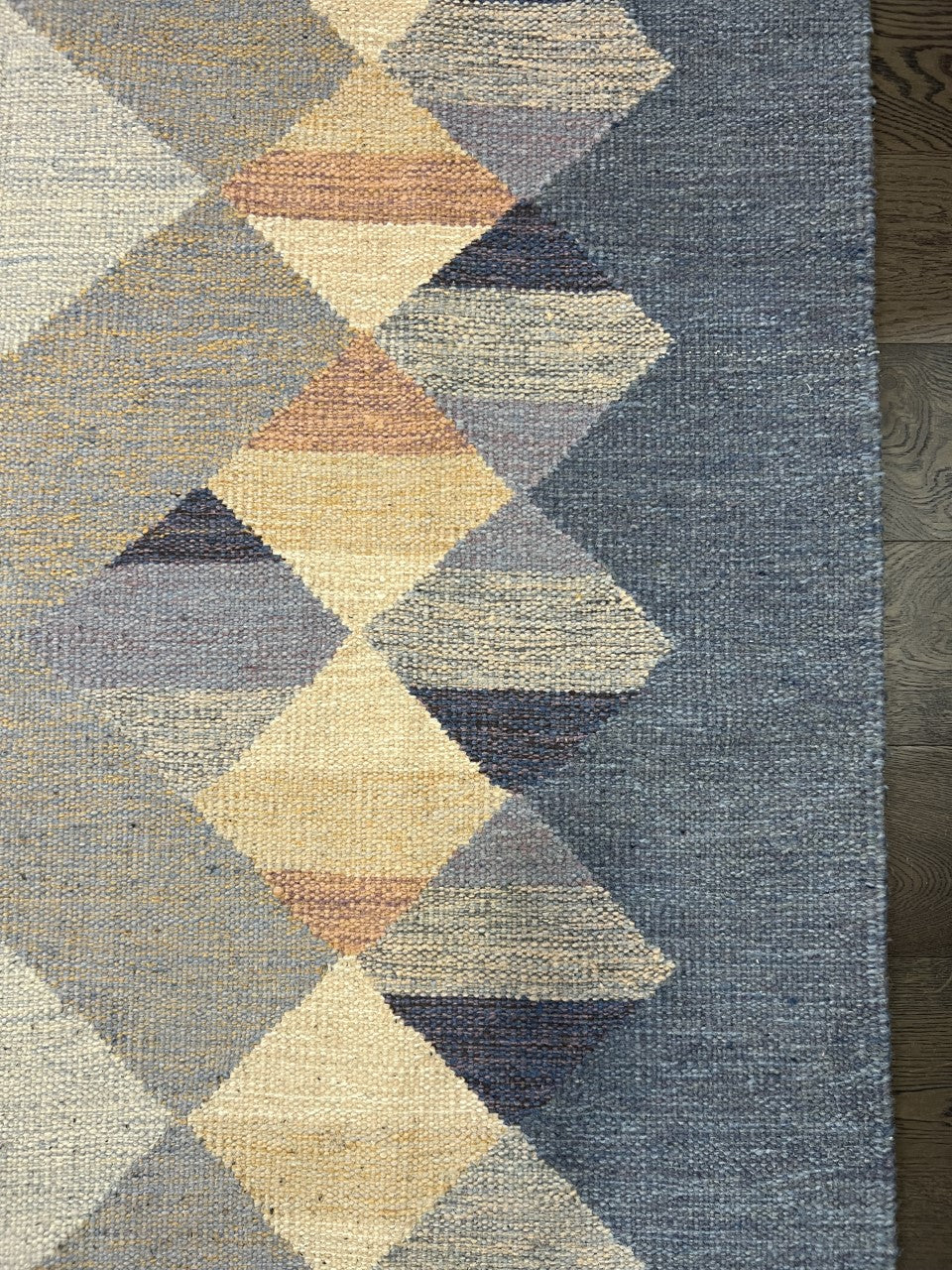 Close-up of Swedish Kilim with repeating diamond motifs in blue, cream and yellow