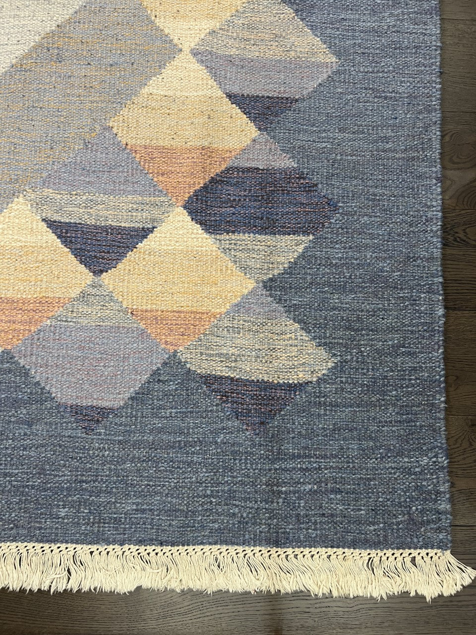 Angled view showing flat-woven texture and geometric diamond pattern